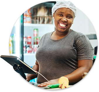 School cafeteria worker smiling holding a computer tablet